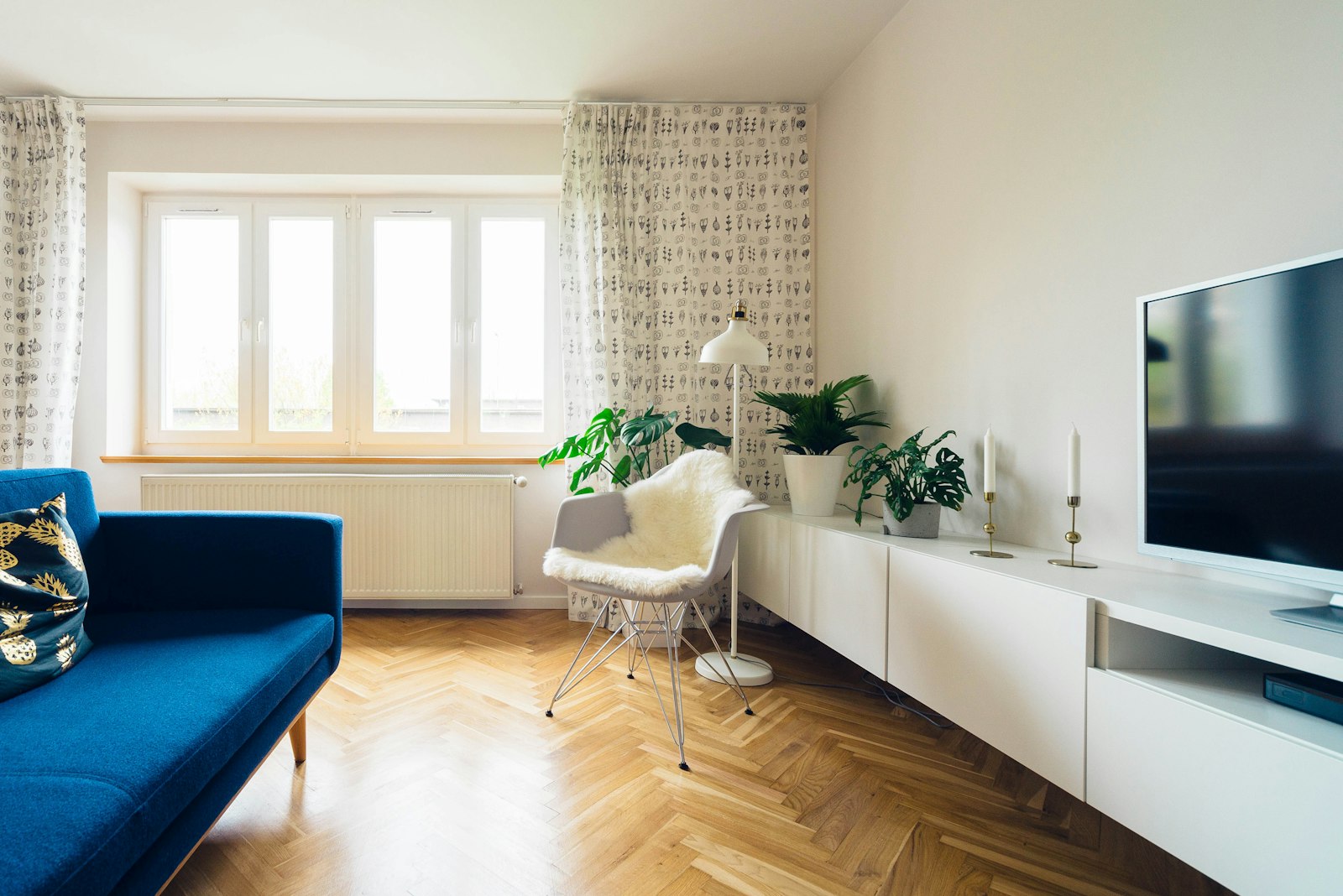A calm living room with a muted green sofa, warm wood coffee table, and soft neutral walls
