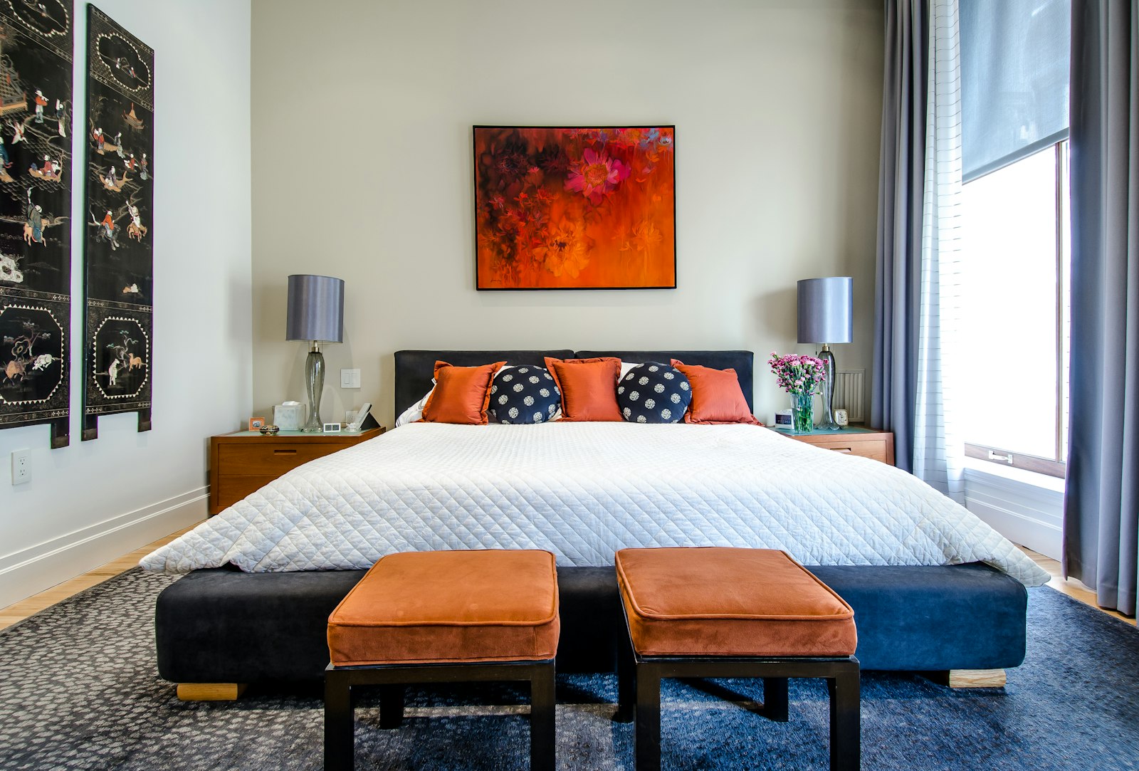 A styled bedside table with a soft lamp, a small stack of books, and a calm neutral arrangement